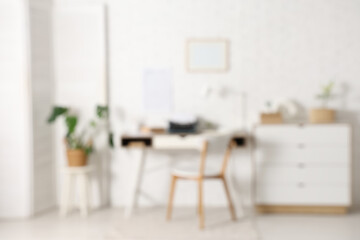Fototapeta premium Blurred view of stylish workspace with vintage typewriter in light living room