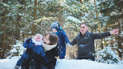 Family enjoying a joyful winter day, playing in the snow amidst the trees of a scenic forest,...