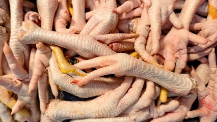 fresh raw chicken feet for sale in traditional market. part of animal body