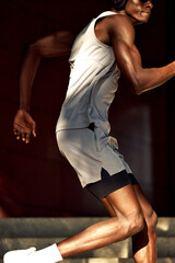 Fototapeta premium Athletic individual running outdoors in sporty attire with headphones