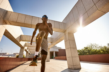 Athletic man performing outdoor exercises in a modern urban setting