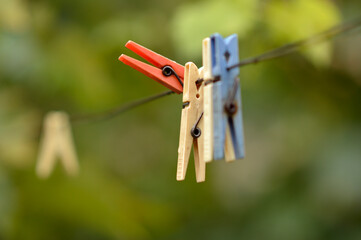 colorful plastic clothes clips hanging on the metal rope