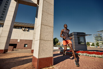 Man jogging outdoors in an urban area on a sunny day