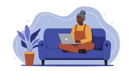 Happy senior woman comfortably uses a laptop on a sofa at home, representing digital literacy, remote work, online learning, and modern living for seniors.