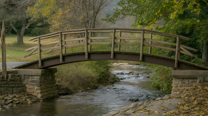 Charming wooden footbridge arching over a flowing stream in autumn park