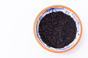 Black Cumin in Terracotta Bowl on White background with Blank Space for Text.