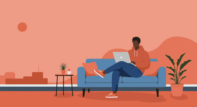 Young Black man comfortably working from home on laptop. Modern living room scene depicting remote work, online learning, or leisure.