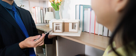 Real Estate Consultation. Agent presenting architectural model to client.