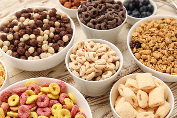 Bowls with different tasty cereals on brown wooden background