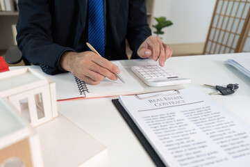 Real Estate Professional. Calculating costs for property transaction with client.