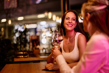 Two Friends Enjoying Wine Together at a Stylish Evening Venue