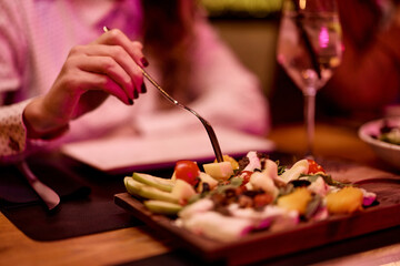 Person Enjoying a Fresh Vegetable Salad in an Upscale Dining Setting