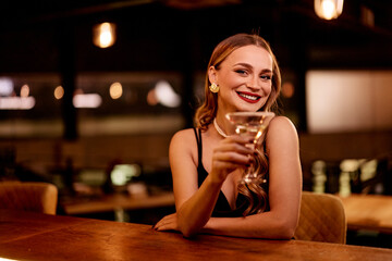 Smiling Woman Enjoying Drink at Stylish Bar with Warm Ambiance