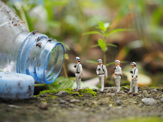 Mini toy of actin figure and bottle plastic with blurred background. Toy photography concept design. Observation team at outdoor scene concept.