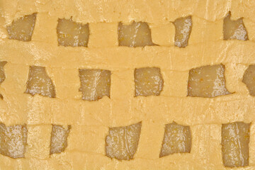 The lattice top crust of an unbaked apple pie, revealing glimpses of the apple filling beneath,...