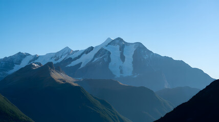 Obraz premium Majestic snow capped mountain peaks under a clear blue sky