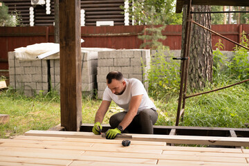 Man carefully marks plans on stand, planning detailed repair while working with wood. Measuring and...