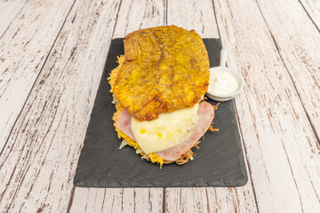 Appetizing detail of a patacón split in half, showing its pale interior contrasting with the...