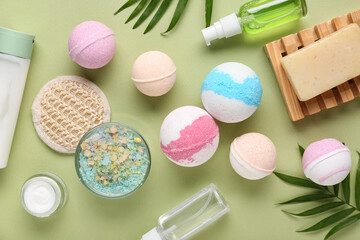 Composition with different bath bombs and cosmetic products on green background