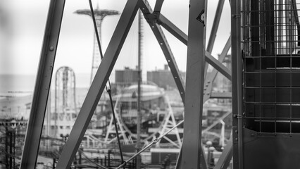 Fototapeta premium Hi-angle shot of Coney Island amusement area with tourists enjoying rides and boardwalk
