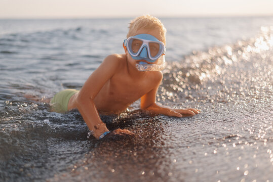 Child wearing snorkel mask entering ocean for exciting underwater adventure