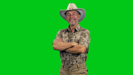 Portrait of smilling middle aged man wearing a khaki shirt with cowboy hat posing with crossed arms...