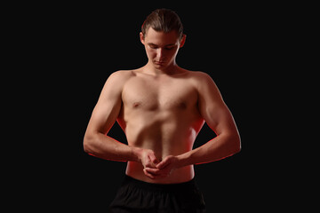 Naklejka premium Sporty muscular man on black background