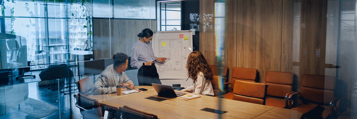 A diverse team is energetically brainstorming and collaborating together in a bright, contemporary office space