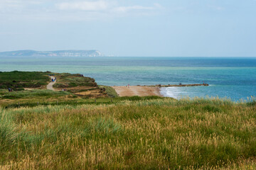 Hengistbury Head, Southbourne, UK - July 1st 2023: View of the Long Groyne on the sandy beach, with the Isle of Wight in the background.