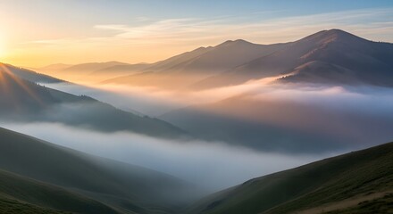 Fototapeta premium Misty mountain landscape at sunrise with warm sunlight and rolling hills