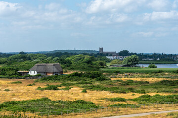 Hengistbury Head, Southbourne, UK - July 1st 2023: The Hengistbury Head Visitor Centre, with Christchurch Harbour and priory in the background.