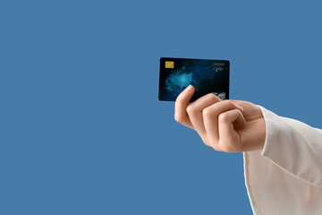 Female hand with credit card on blue background