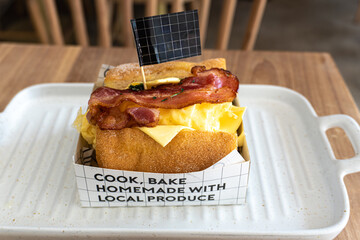 A slice of delicious, fresh bacon with egg toast on a wooden table