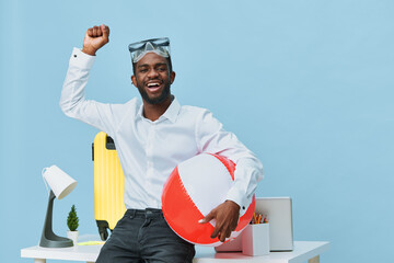 Happy young man with dark skin and beard in casual white shirt holding a red and white beach ball,...
