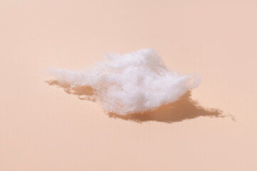 Delicate fluffy pieces of cotton wool on beige background, top view. Cotton clouds, natural...