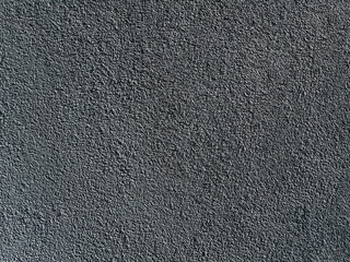 Textured dark gray wall surface with a rough finish, ideal for backgrounds or artistic design projects with copy space