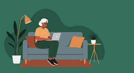 A senior woman comfortably uses a laptop on her sofa at home, representing modern remote work, online learning, and digital literacy for older generations.