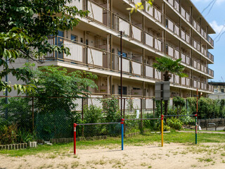 公園の鉄棒と廃墟の団地