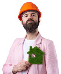 Portrait of young construction engineer wear orange hard hat, in a pink jacket standing on red studio background. A man holds a green eco house.