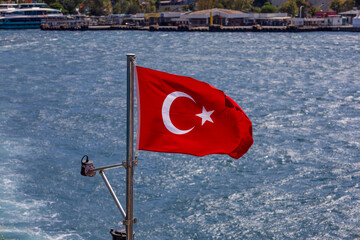 Turkish National Flag Waving on Boat with Blue Sea Background