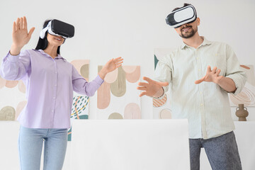 Young couple with VR glasses near pedestal in modern art gallery