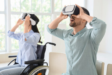 Young woman in wheelchair and man with VR glasses visiting modern art gallery