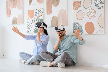 Shocked young couple using VR glasses near paintings in modern art gallery