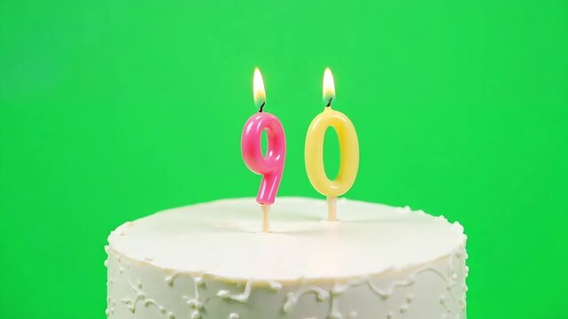 Celebrate a milestone 90th birthday with bright, flickering candles atop a festive white cake, perfect for joyous anniversaries and special occasions.