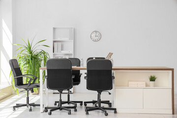 Interior of conference hall with desk, shelf unit and palm plant