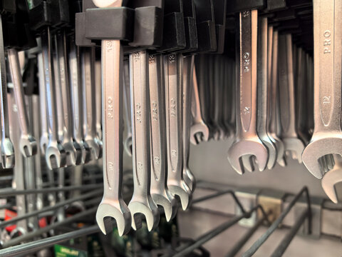 Shiny wrenches lined up in a tool display at a hardware store