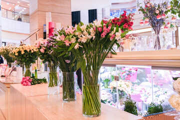 A display of flowers in vases on a counter in a store