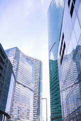 Obraz premium Modern glass skyscrapers reaching high in the sky. Cityscape architecture with office building facades for finance business and urban development.