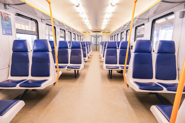 A train car with blue seats and a yellow sign on the wall