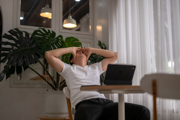 Stressed asian freelancer holding head in hands at home office desk